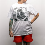 Person wearing a white t-shirt with black graphic design and red shorts on a plain background. palestine fundraiser. all proceeds go to families in need.